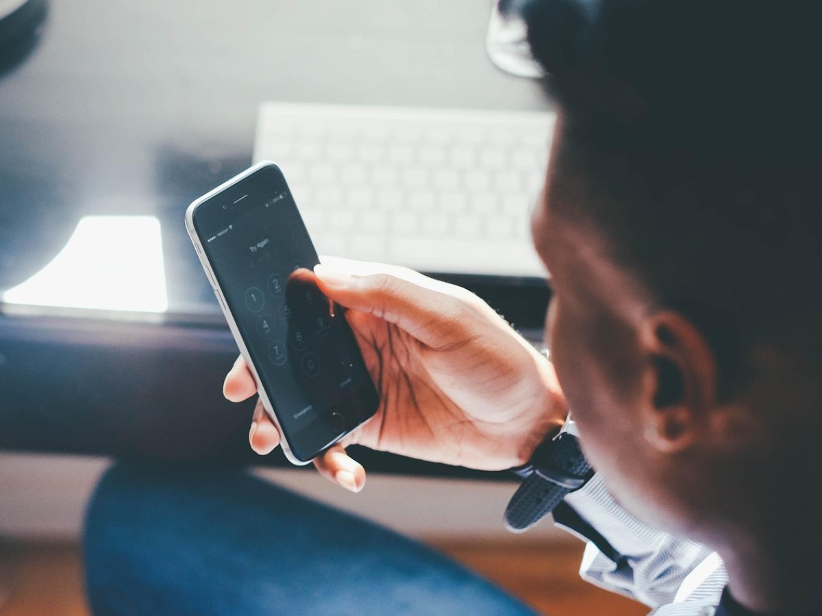 片子网站 App 首页界面在手机屏幕上展示，暖橙色分类标签与深棕色导航栏并排，用户在柔和室内光线下浏览片单