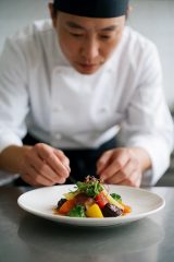 美食纪录片封面,精致菜肴特写,色彩鲜艳诱人,厨师专注烹饪的画面充满匠心